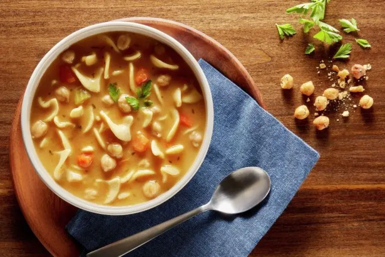 A group of bowls of Progresso soup and croissants on a white table